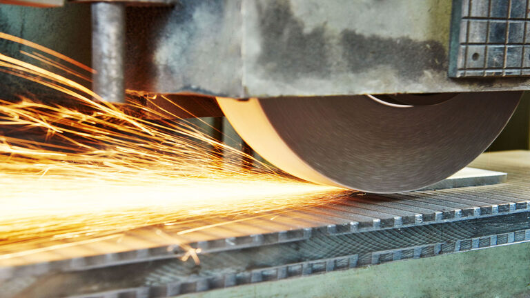 metalworking machining industry. finishing or grinding metal surface on horizontal grinder machine at factory